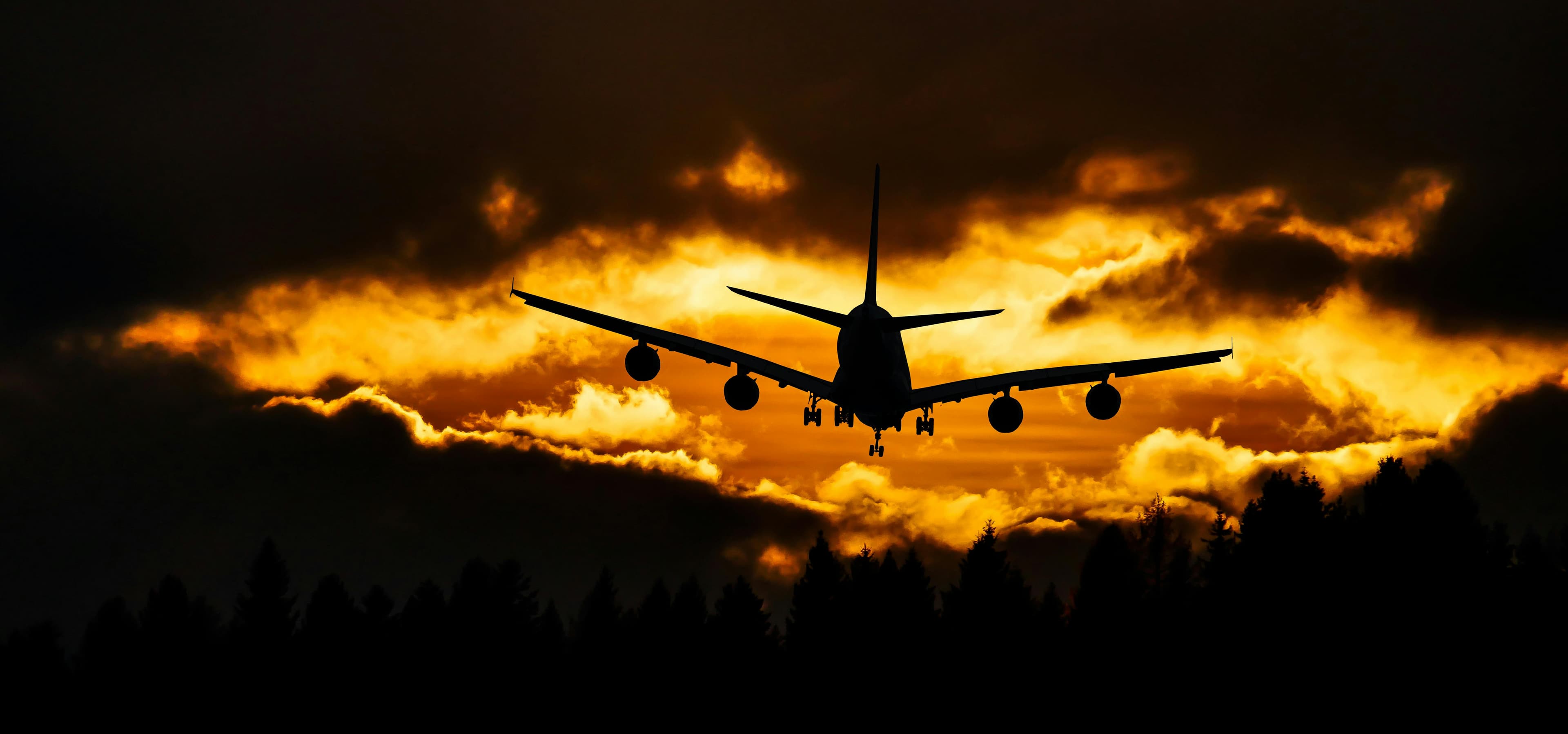 Silhueta de um avião comercial no pôr do sol